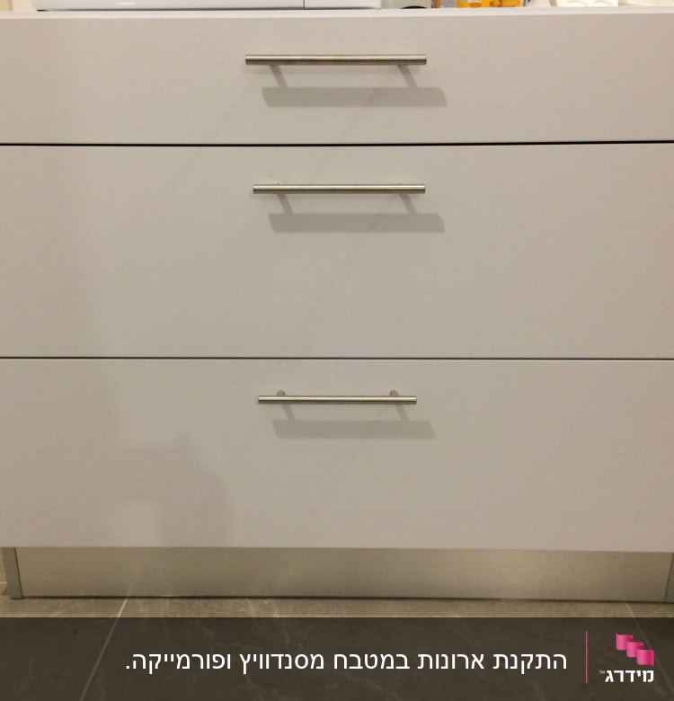 ארון מטבח לבן עם שלוש מגירות וידיות מתכת